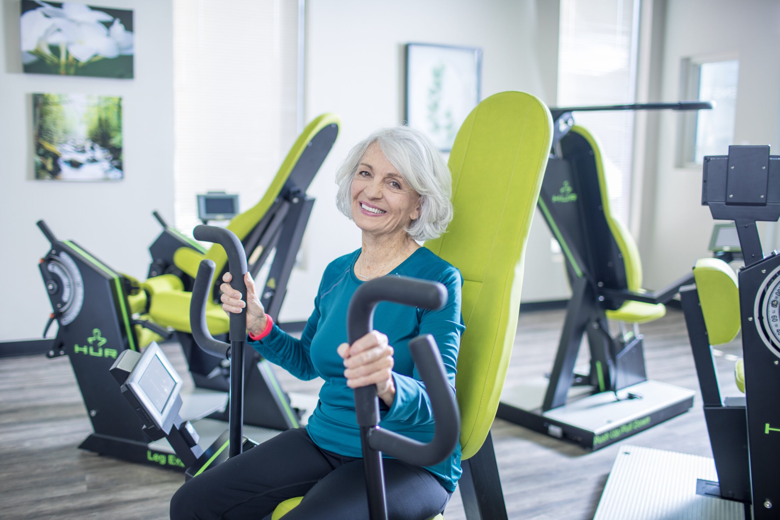 Femme agée sur machine de renforcement musculaire